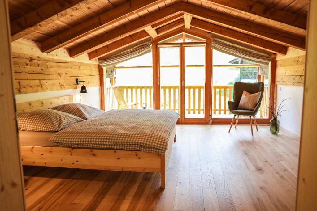 ein Schlafzimmer mit einem Bett und einem Stuhl in einem Zimmer in der Unterkunft Ferienwohnungen Antenbichllehen in Berchtesgaden