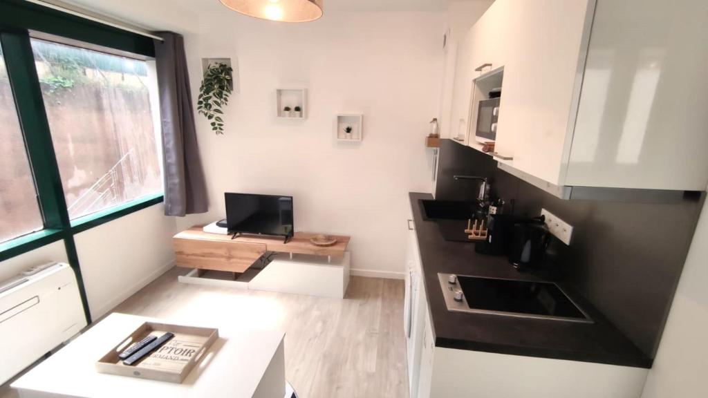 Elle comprend une petite cuisine avec un bureau et une fenêtre. dans l'établissement Dana centre mer 25, à Nice