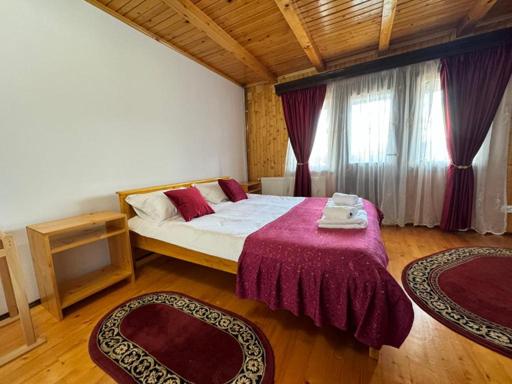 - une chambre avec un lit et deux tapis dans l'établissement Casa Amalia Tocile -Sadu, à Sadu