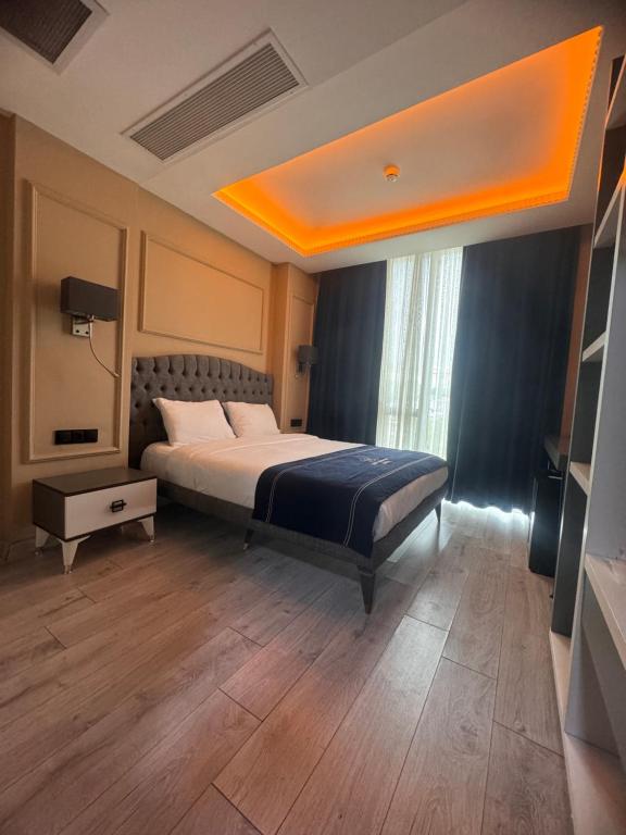 a bedroom with a large bed with an orange ceiling at Loft Airport Hotel's in Arnavutköy