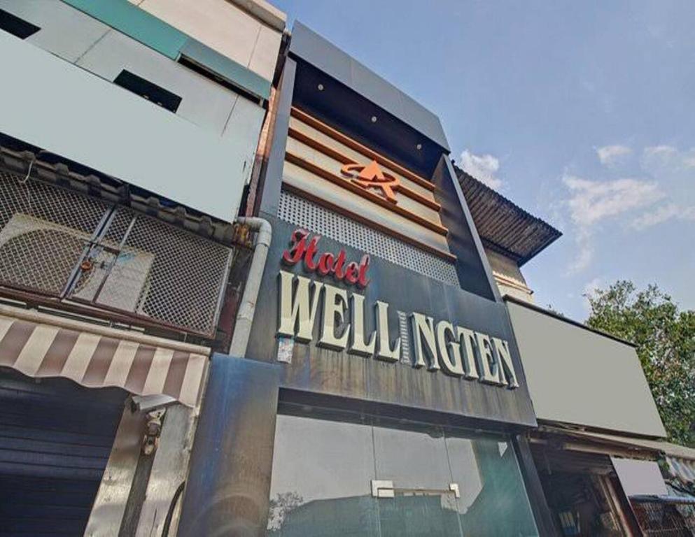 a building with a sign on the side of it at Hotel Wellingten in Mumbai