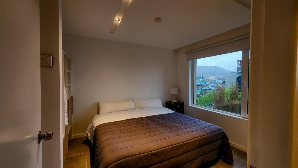 a bedroom with a bed and a large window at Ushuaia Center Apartament Suit in Ushuaia