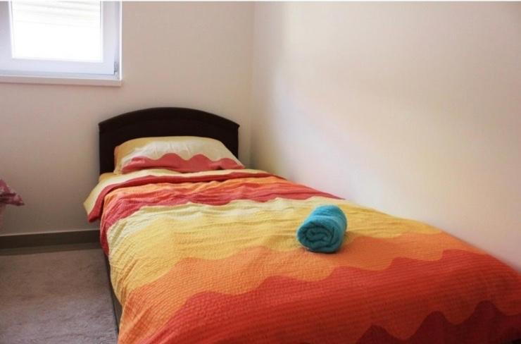 1 dormitorio con 1 cama con una manta colorida en Apartman Maja en Igalo
