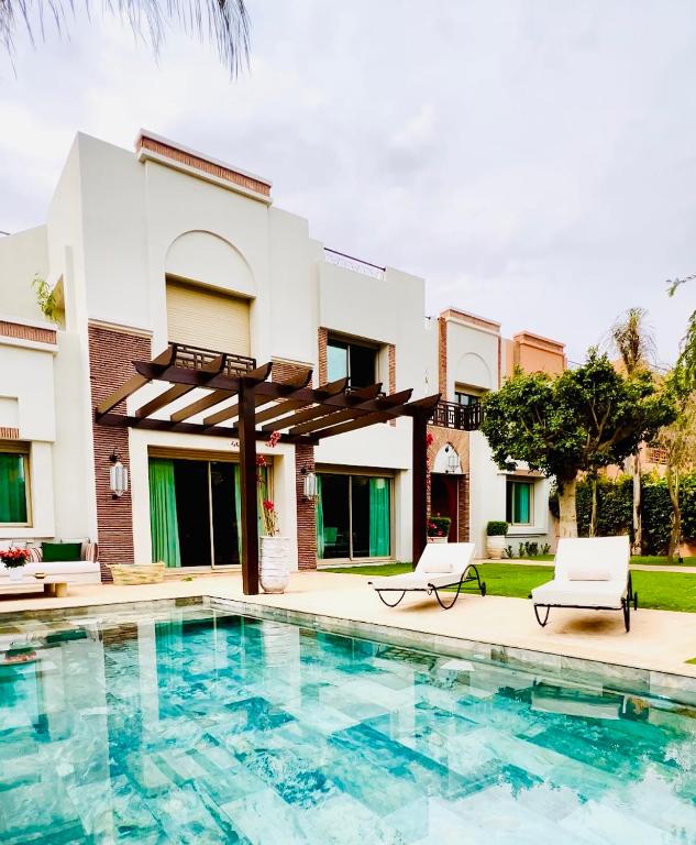 een villa met een zwembad en een huis bij Villa Jenna in Marrakesh