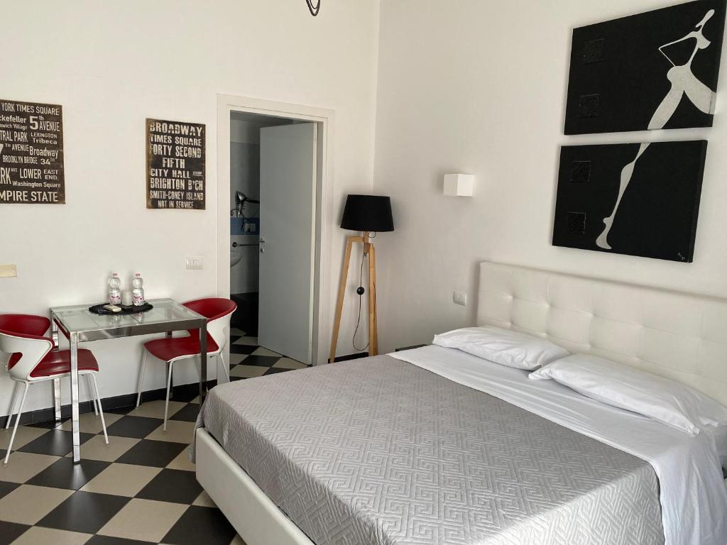 a bedroom with a bed and a table with chairs at Manì Rooms in Cagliari