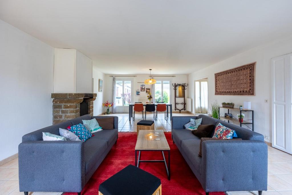 - un salon avec deux canapés bleus et un tapis rouge dans l'établissement Le Nest quiet house in city center, à Bayeux