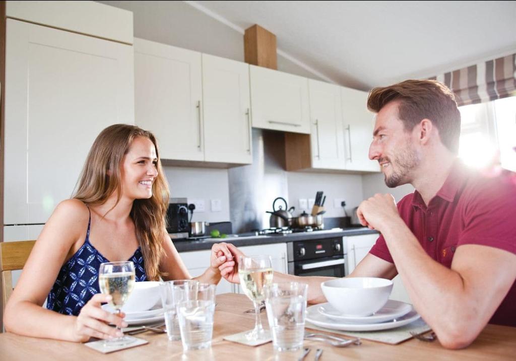 een man en vrouw aan een tafel in een keuken bij Wigmore Lakes Lodges in Cardeston