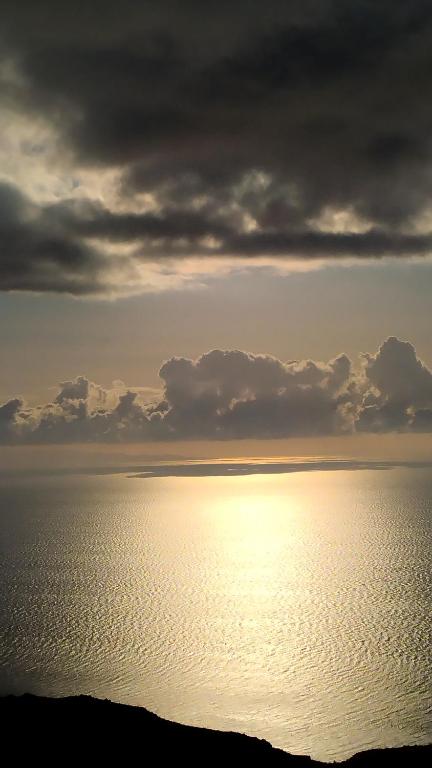 a view of the ocean with the sun reflecting on the water at AegeanDeepBlue2 in Apróvaton