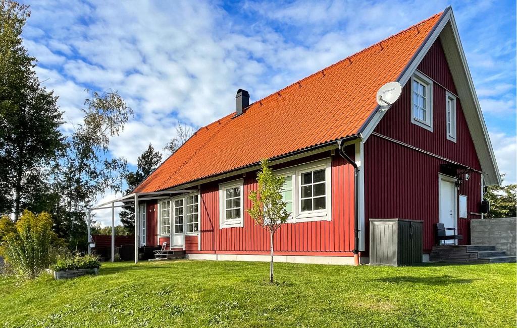 a red house with an orange roof at Cozy Home In Nykping With House Sea View in Oxelösund