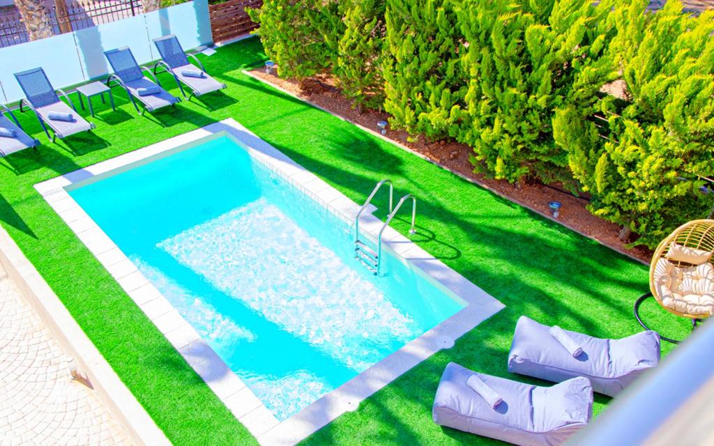 an overhead view of a swimming pool with chairs and grass at Gournes Mare Luxury Villa with private pool in Gournes