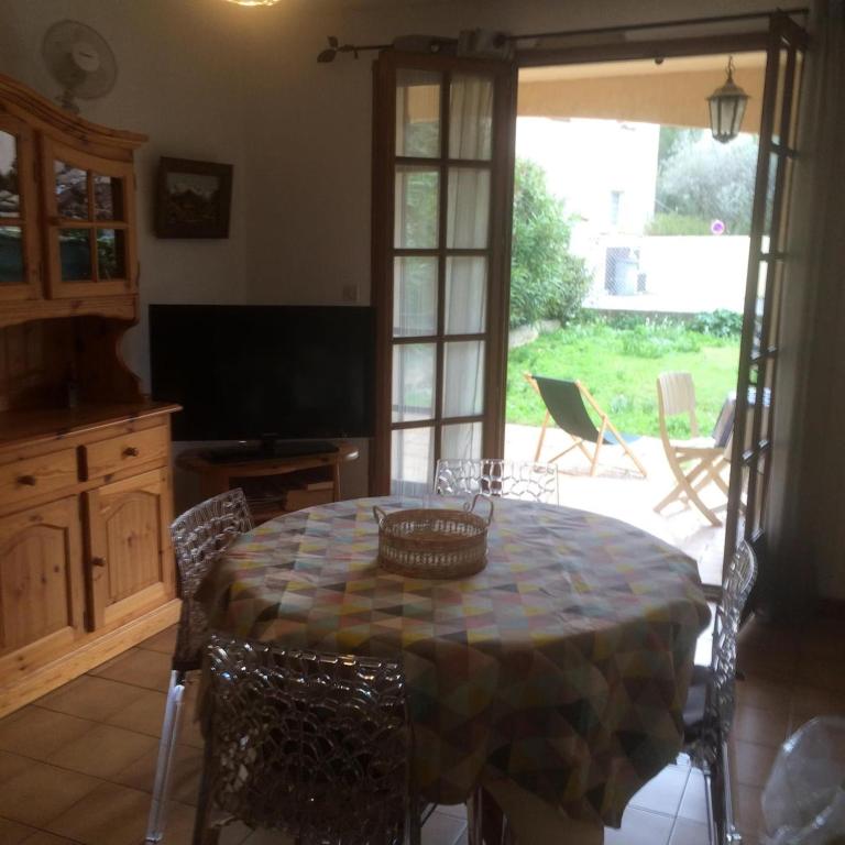 une salle à manger avec une table, des chaises et une télévision dans l'établissement Coeur de ville avec jardin privatif, à Sanary-sur-Mer
