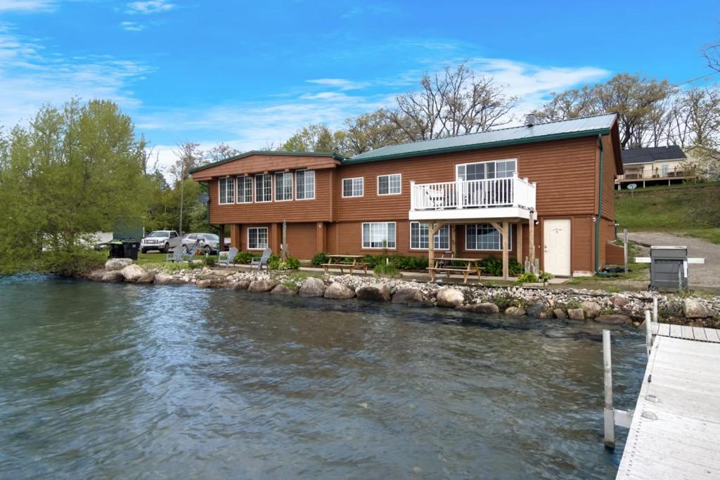 a house next to a river with a house at 3 Units on Fife Lake with Hot Tub-Sleeps 18 in Fife Lake