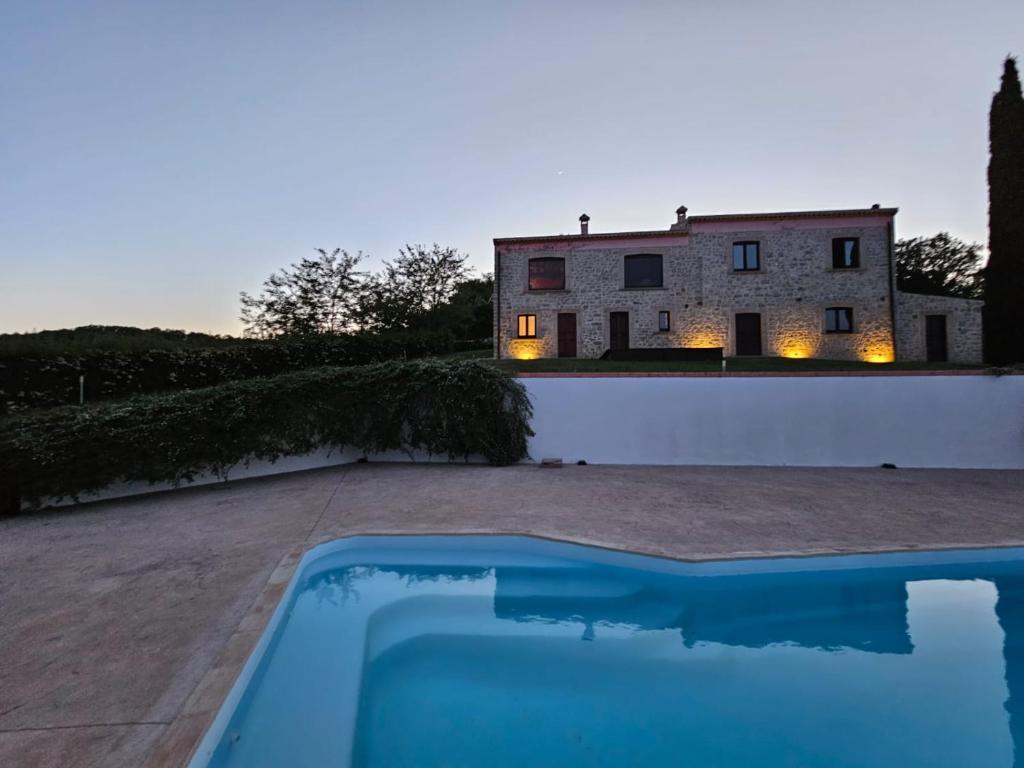 Villa con piscina frente a un edificio en Casolare Abruzzese : natura, incanto e mindfulness, en Carunchio