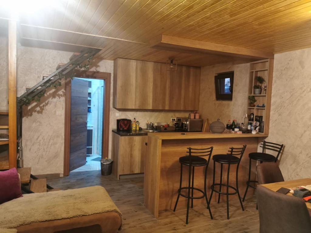 a kitchen with a counter and stools in a room at Vikendica na Drini in Banja Koviljača