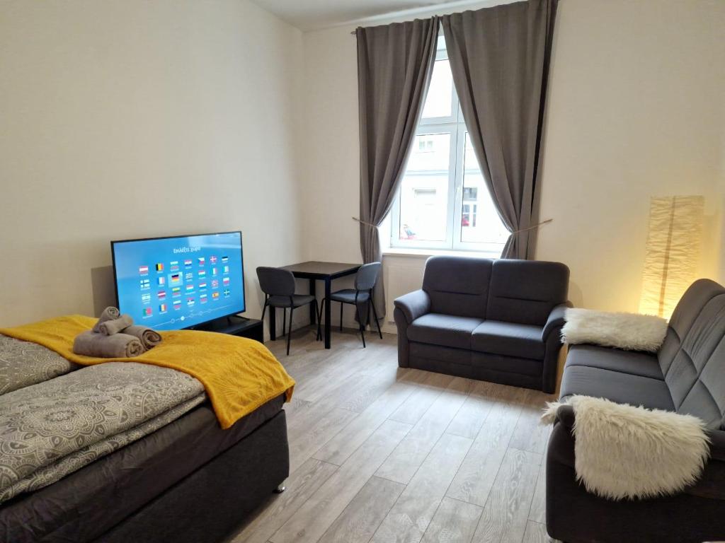 ein Schlafzimmer mit einem Bett, einem Sofa und einem Stuhl in der Unterkunft RPStay in Wien