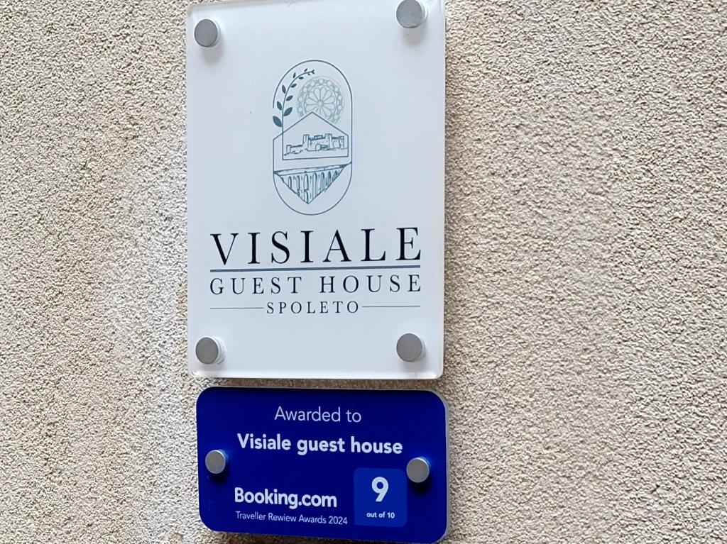 un cartello per una pensione su un muro di Visiale guest house a Spoleto