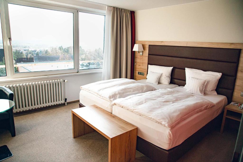 a bedroom with a large bed and a large window at Hotel Panorama in Einbeck