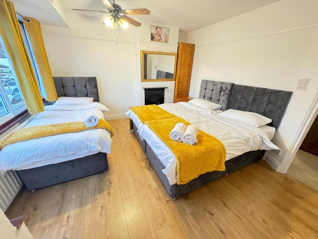 a bedroom with two beds with towels on them at Golden Villa in Uxbridge