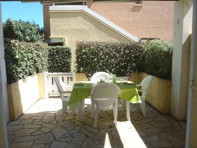 une table et des chaises avec une nappe verte sur la terrasse dans l'établissement APPT 3 PIECES 32m2 + TERRASSE 13m2 REF 4050, à Le Castellas