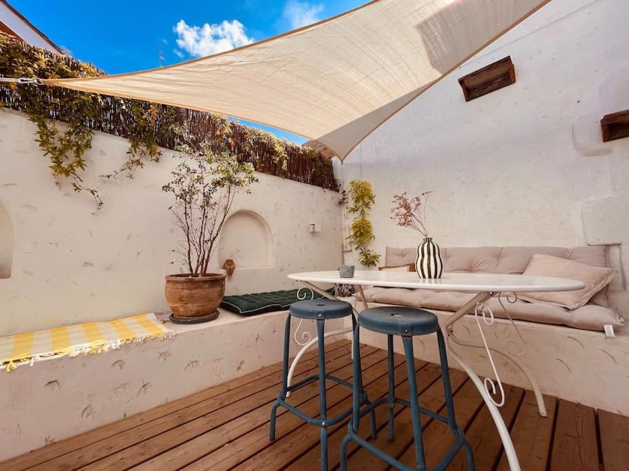 eine Terrasse mit einem Tisch und 2 Hockern in der Unterkunft Superbe maison à 5 min de Bordeaux in Le Bouscat