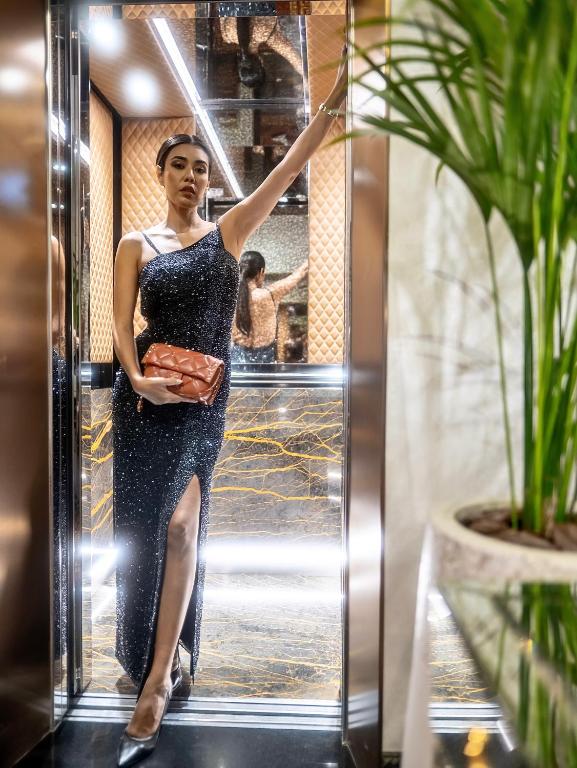 a woman in a dress standing in front of a mirror at Golden Sands Boutique Hotel-Dubai Creek in Dubai