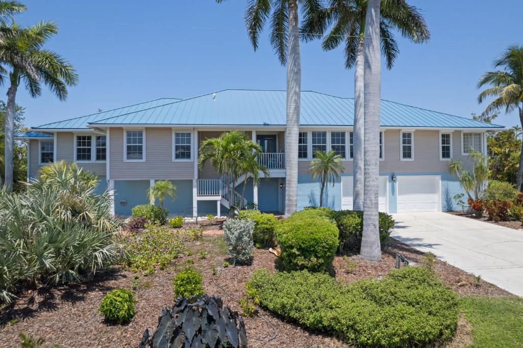 a house with palm trees in front of it at Gorgeous 5 Bedroom Home with Heated Pool and Spa in Sanibel