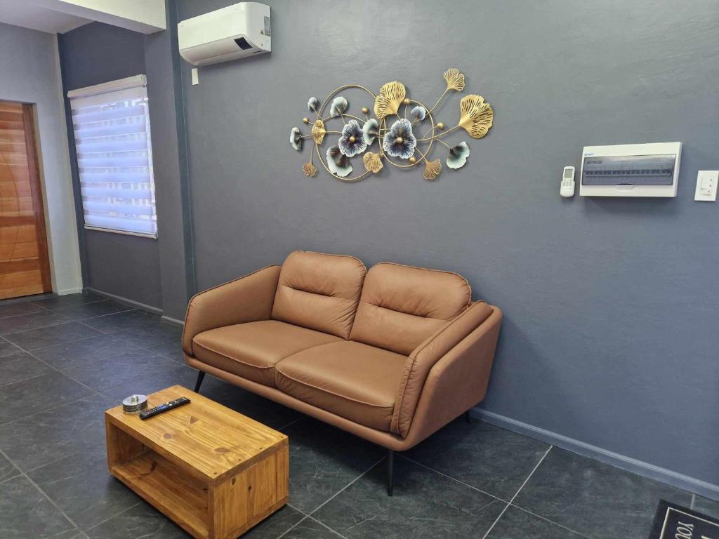 a waiting room with a brown couch and a table at S & R Homes in Tacloban