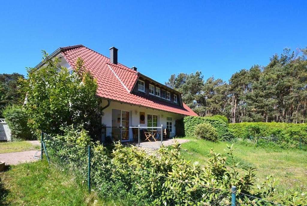 a house with a red roof on a field at Dünenvilla 4 in Thiessow in Göhren