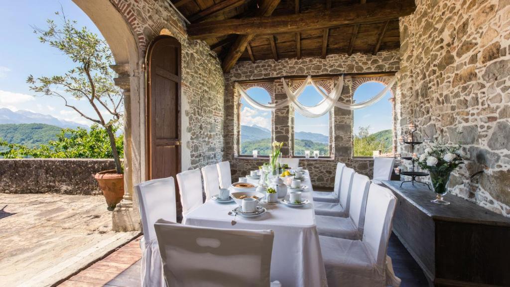 ein Esszimmer mit einem Tisch und weißen Stühlen in der Unterkunft Villa Raffaelli in Fosciandora