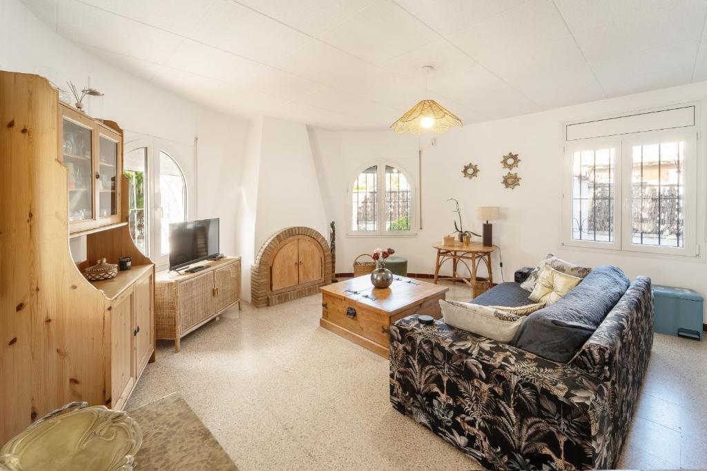 a living room with a couch and a tv at WELCS CASA 147 EMP cerca del mar in Empuriabrava