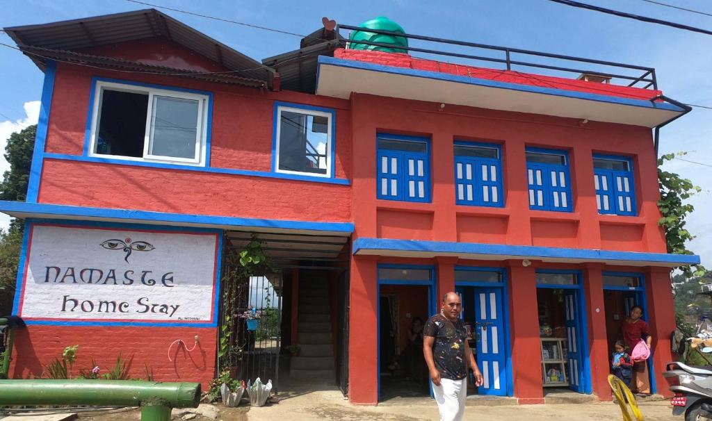 a man standing in front of a home stay at Namaste Home Stay in Dhulikhel