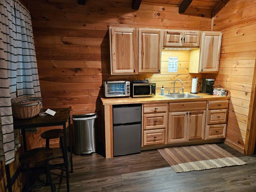 a kitchen with wooden cabinets and a sink and a stove at Sylvan Valley Lodge and Cellars in Sautee Nacoochee