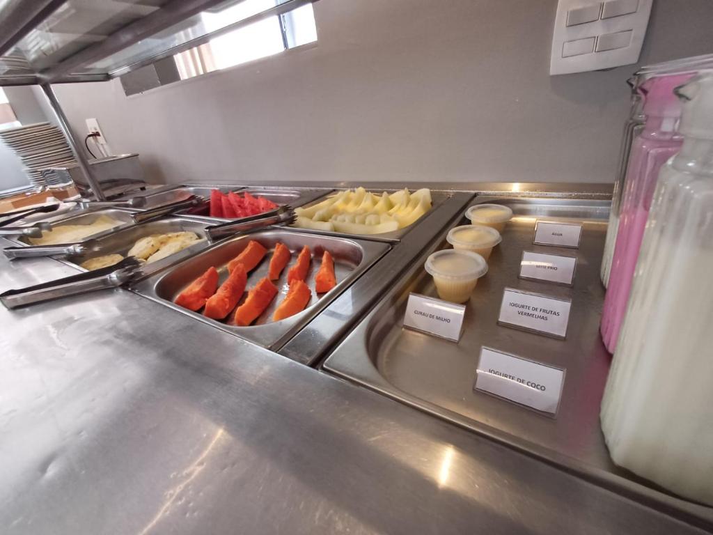 a buffet line with hot dogs and other foods at Hotel Bella Paulista in Sao Paulo