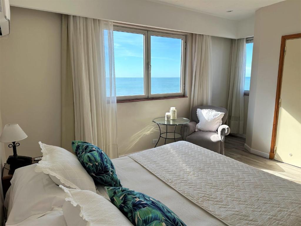 a bedroom with a bed with a view of the ocean at Hotel Guerrero in Mar del Plata