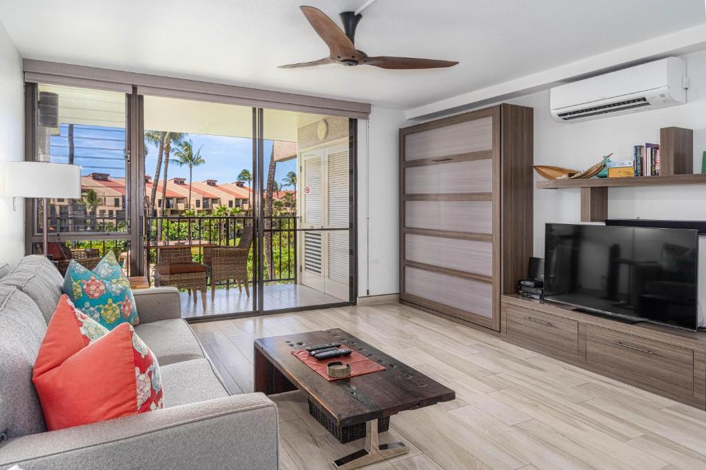 a living room with a couch and a tv at Kamaole Sands 3-303 in Wailea