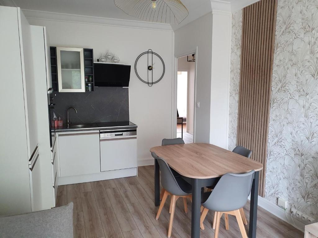 une cuisine et une salle à manger avec une table et des chaises en bois dans l'établissement Raffinement proche Grenoble Centre, à Grenoble