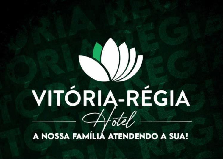 ein weißes Logo auf grünem Hintergrund mit einem Schild in der Unterkunft HOTEL Vitoria Regia in Brasiléia