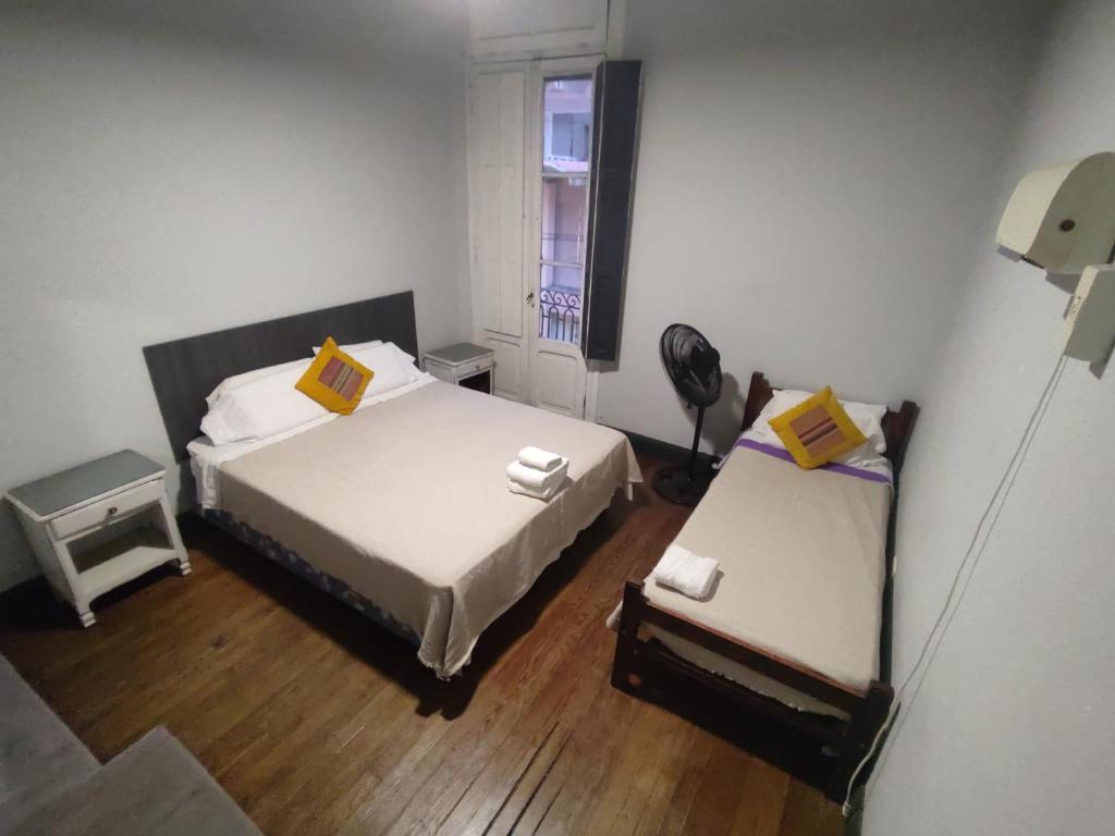 een kleine kamer met twee bedden en een raam bij Hostal Vampayá in Salta