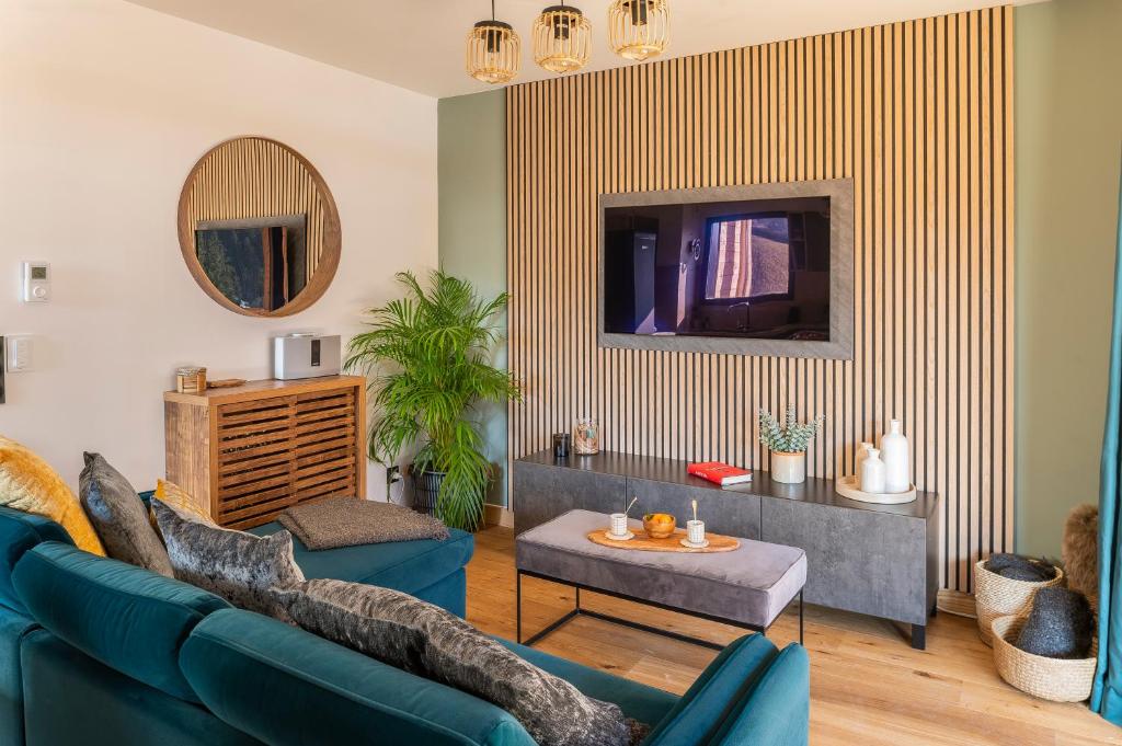 un salon avec un canapé bleu et une télévision dans l'établissement Apartment Cairn Harmony B104, aux Gets