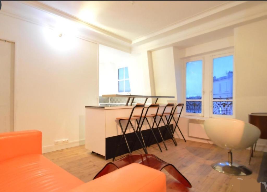 - un salon avec un canapé orange et une table dans l'établissement Sweet home, à Saint-Denis
