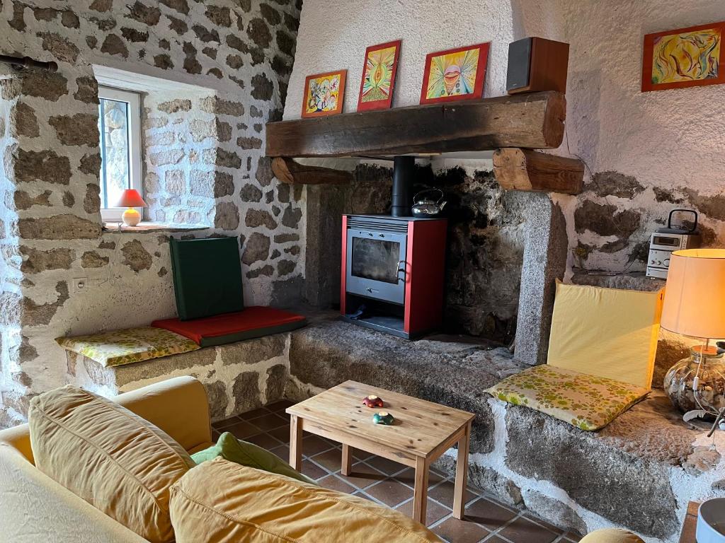 a living room with a couch and a fireplace at Loft du Moulin Chandy in Usson-en-Forez