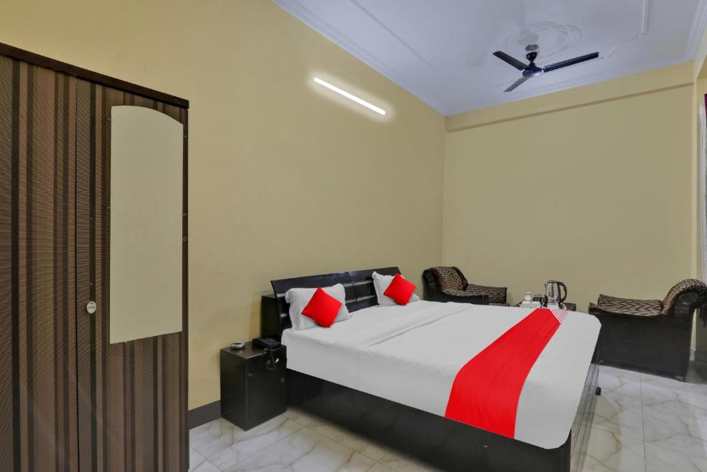 een slaapkamer met een bed met een rode en witte deken bij OYO Flagship Hotel New A V Hospitality in Chinhat