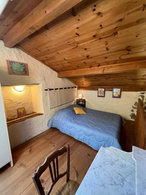 a bedroom with a bed in a room with wooden ceilings at Loft du Moulin Chandy in Usson-en-Forez