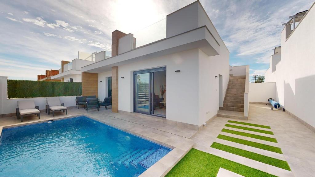 a villa with a swimming pool in front of a house at Villa Solar - A Murcia Holiday Rentals Property in Roldán