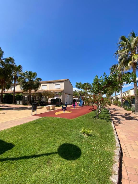 ein Park mit Palmen und ein Gebäude in der Unterkunft Río Palancia, Disfruta de una estancia en Familia in Oropesa del Mar