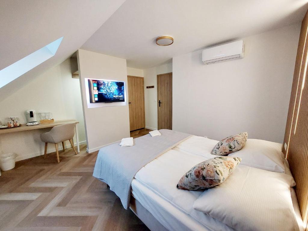 ein Schlafzimmer mit einem Bett mit zwei Kissen darauf in der Unterkunft Kwietny Stoczek 70 in Białowieża