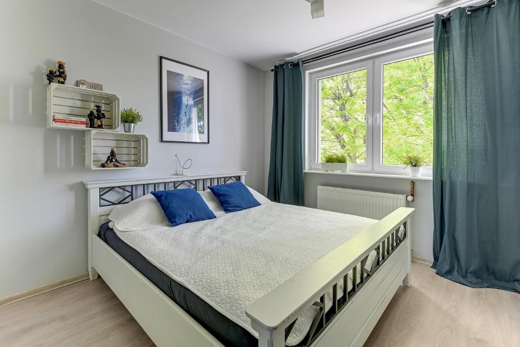 ソポトにあるSopot Dream Apartments- Alphaのベッドルーム1室(青い枕のベッド1台、窓付)