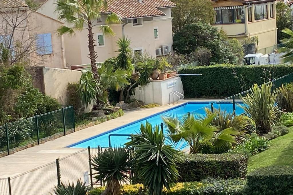 a swimming pool in a yard with a house at Cosy apartment 7 minutes walk from the sea! in Mandelieu-la-Napoule