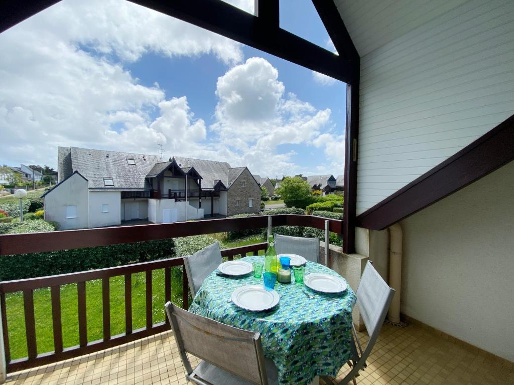 - une table sur un balcon avec vue sur une maison dans l'établissement REFLETS - Duplex avec balcon, Piscine - T110, à Carnac