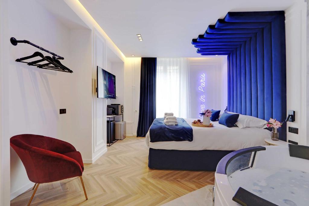 a bedroom with a large bed with blue curtains at Lovely Bedroom with Jacuzzi 2P Chatelet in Paris